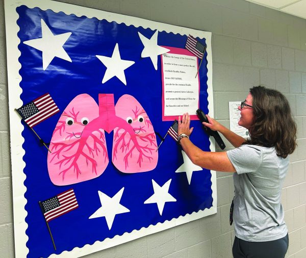 Getting crafty…Decorating the bulletin board outside the nurses’ office, school nurse Jennifer Kaufman finalizes the last bulletin board of the 2025-2026 school year. Kaufman hopes the bulletin boards enlighten teens about their health.